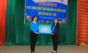 Trao bảng tượng trưng ủng hộ các hoạt động của Chương trình “Đồng hành cùng phụ nữ biên cương” trên địa bàn huyện Tân Hồng. Ảnh: Nhựt An - TTXVN