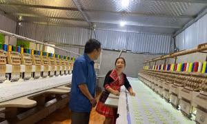 Ông Lầu Văn Thào, Bí thư Chi bộ, người uy tín thôn Nà Tang, xã Hùng Lợi thăm mô hình dệt của hộ dân trên địa bàn. Ảnh: Thu Huyền