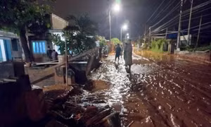 Một phần tuyến đường Lạc Long Quân thuộc xã Tiến Thành, thành phố Phan Thiết bị cát đỏ tràn xuống gây ngập đường. Ảnh: Nguyễn Thanh - TTXVN