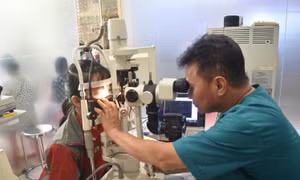 Bác sĩ Chuyên khoa II Ngô Văn Cường, Trưởng Khoa Mắt, Bệnh viện Đa khoa vùng Tây Nguyên thăm, khám cho bệnh nhi bị đau mắt đỏ. Ảnh: Nguyên Dung – TTXVN