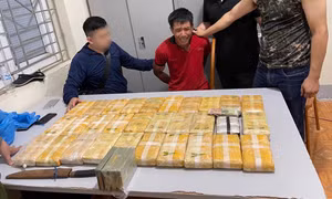 Đối tượng Thạo Bun Phúc (áo đỏ) cùng tang vật vụ án. Ảnh: thanhnien.vn