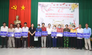 Trao bảng tượng trưng bàn giao nhà đại đoàn kết cho hộ nghèo. Ảnh: Thanh Hòa - TTXVN