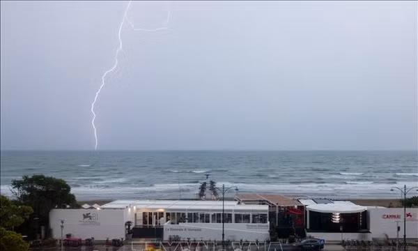 Tia sét trên bầu trời gần đảo Lido, Venice, Italy, trước khi bão đổ bộ. Chuyên gia cho biết nồng độ hơi nước tăng cao có thể làm tăng nguy cơ mưa lớn, bao gồm cả mưa do lốc xoáy và cung cấp thêm năng lượng cho các cơn bão. Ảnh: THX/TTXVN