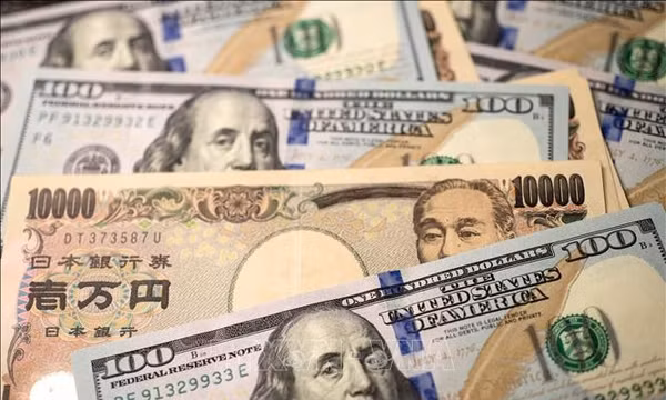 Đồng tiền 10.000 yen của Nhật Bản và đồng 100 USD. Ảnh: THX/TTXVN