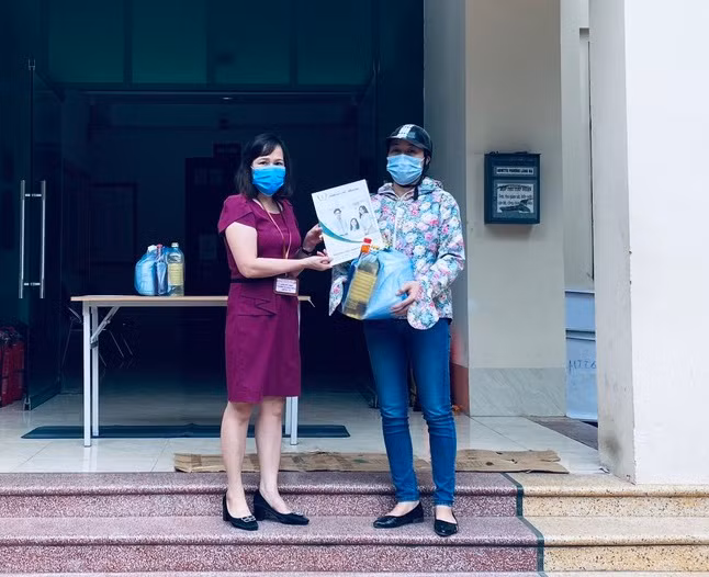 Bà Bùi Thị Nhung nhận hỗ trợ từ Ủy ban MTTQ phường Láng Hạ (Hà Nội). Ảnh: XM
