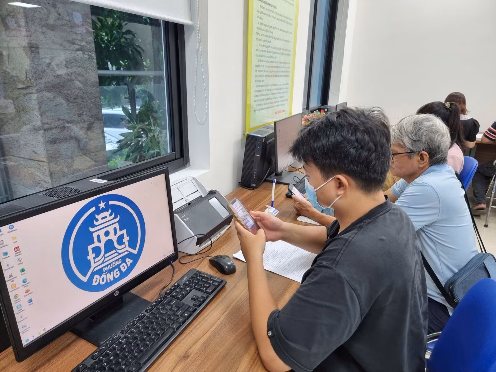 Anh Phạm Hoàng Long đang làm thủ tục khai sinh cho con tại Điểm tiếp nhận hồ sơ thủ tục hành chính phường Đống Đa.