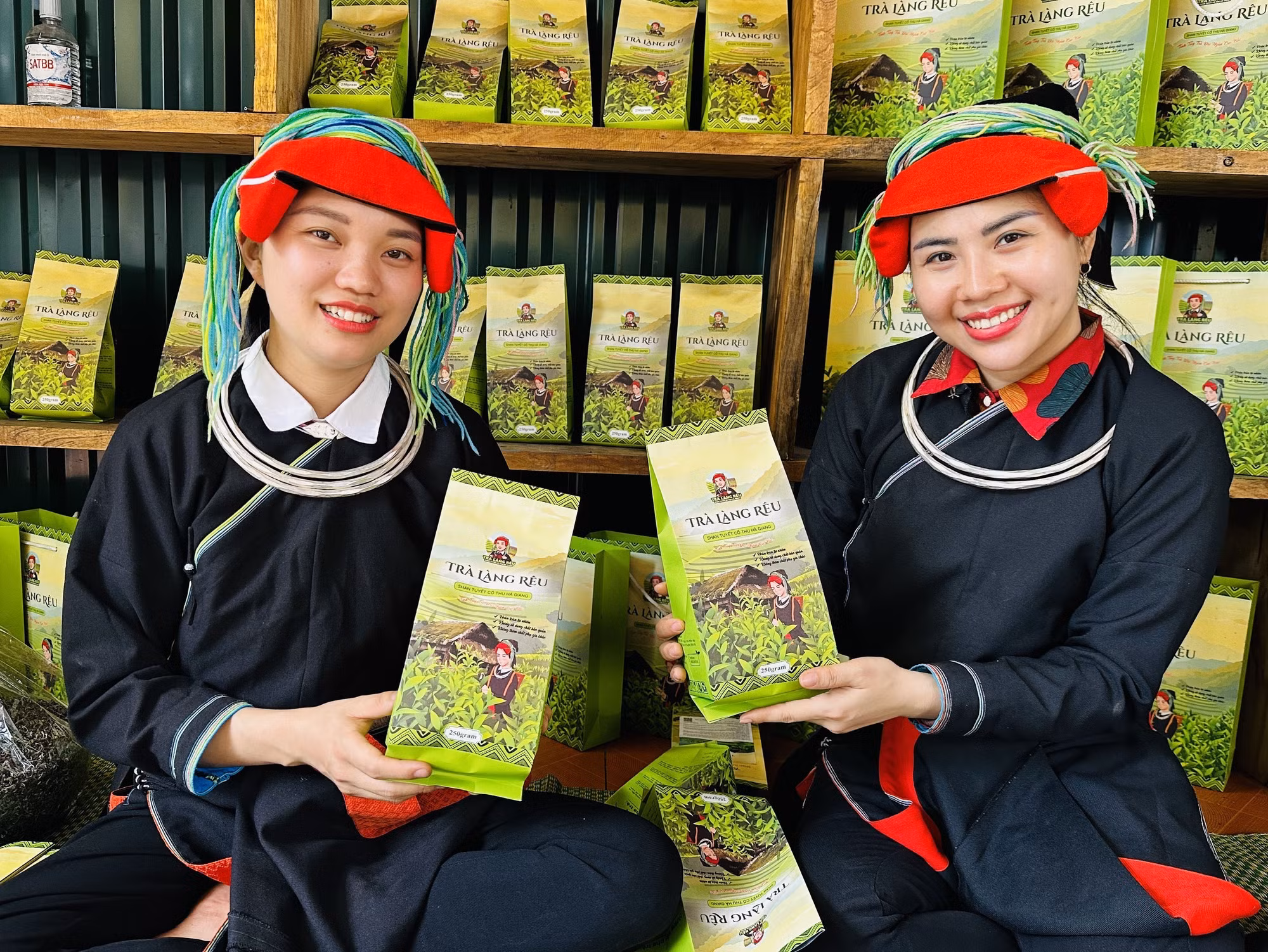 Cô gái người Dao Bàn Thị Hom (bên trái) giới thiệu sản phẩm chè tự tay mình làm nên