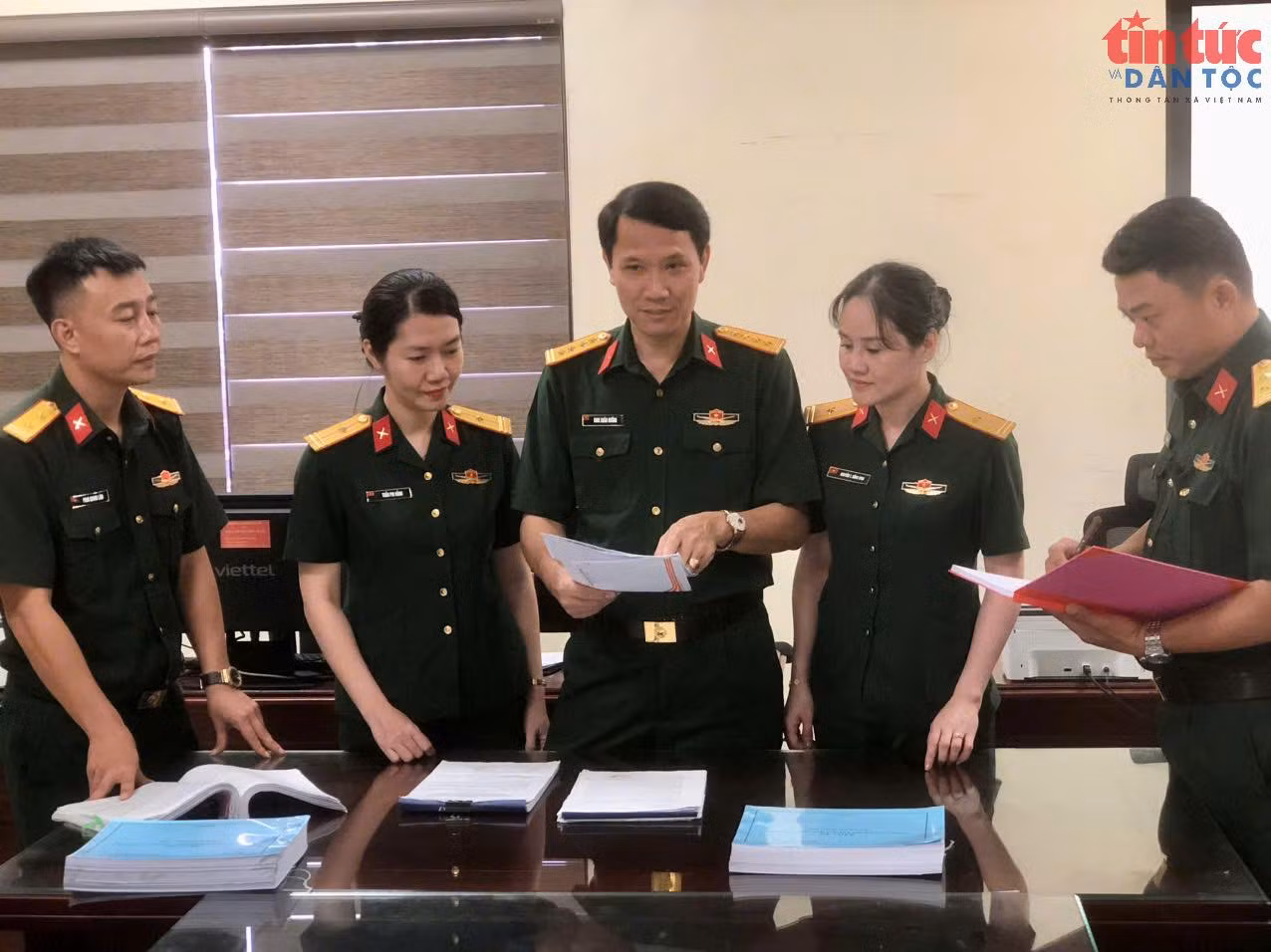 Đại tá Đinh Xuân Hướng (người đứng giữa ảnh), Phó Chủ nhiệm Chính trị Quân khu 4 trao đổi với các cán bộ, nhân viên Phòng Chính sách về việc rà soát danh sách các liệt sĩ đã được tìm thấy sau khi quy tập về nghĩa trang trên địa bàn Quân khu.