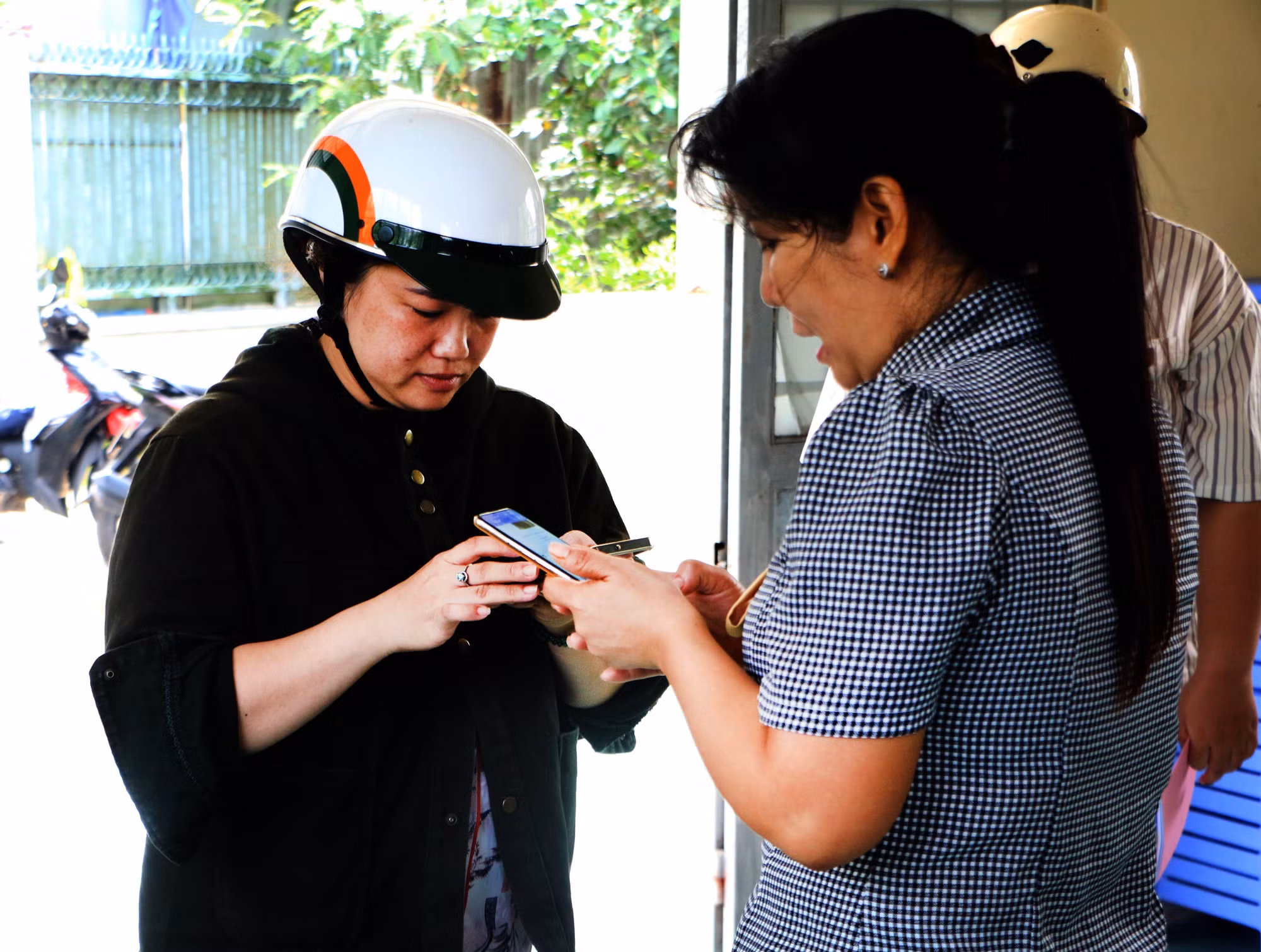 Bà Vũ Thị Thúy Hằng, Trưởng Khu vực 5 (phường Vị Tân, thành phố Cần Thơ) hướng dẫn người dân sử dụng điện thoại thông minh thực hiện dịch vụ công trực tuyến. Ảnh: Duy Khương/TTXVN