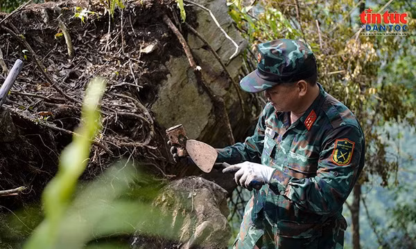 Kiểm tra vật dụng được phát hiện trong quá trình tìm kiếm hài cốt liệt sĩ tại hiện trường. Ảnh: LP