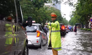 Bóng 'áo vàng' dầm mưa, lội nước phân luồng giao thông trong mưa ngập 