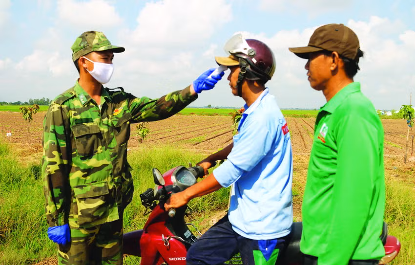 Cán bộ, chiến sĩ phòng, chống dịch COVID-19 số 4 thuộc Đồn Biên phòng quốc tế Vĩnh Xương (Bộ đội Biên phòng tỉnh An Giang) thường xuyên kiểm tra thân nhiệt người dân. Ảnh: Công Mạo – TTXVN