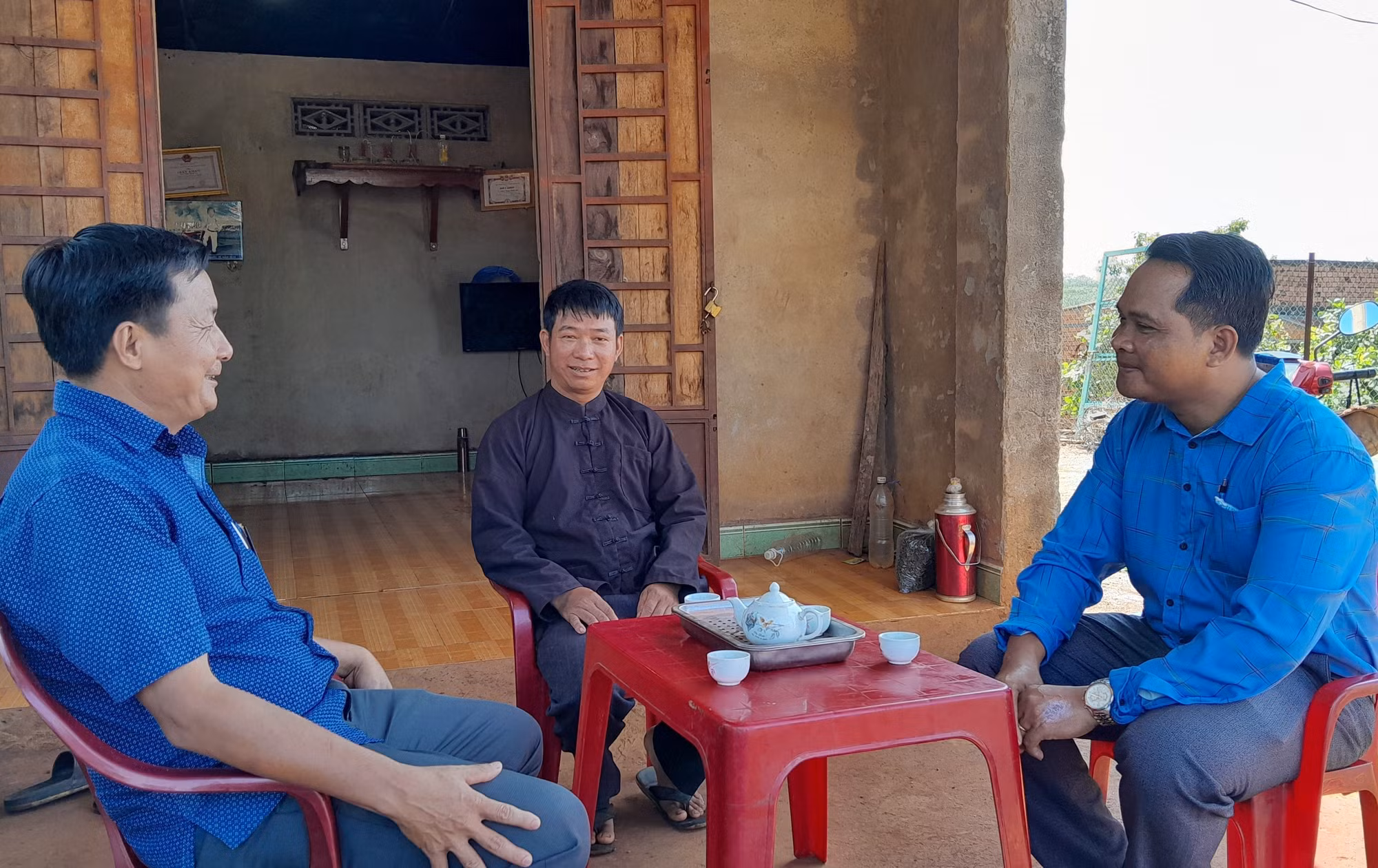 Người có uy tín Khằm Thanh Sơn (giữa), thôn 10, xã Đắk Ơ, huyện Bù Gia Mập được lãnh đạo Phòng Dân tộc - Tôn giáo huyện Bù Gia Mập và xã Đắk Ơ thăm hỏi. Ảnh: K GỬIH-TTXVN
