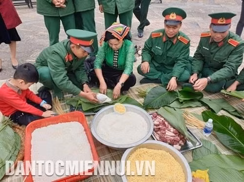 Đồng bào và các chiến sĩ cùng tham gia gói bánh chưng tặng cho người nghèo tại Làng Văn hóa - Du lịch các dân tộc Việt Nam trong chương trình "Gói bánh chưng xanh cùng người nghèo ăn Tết”. Ảnh: Hoàng Hải 