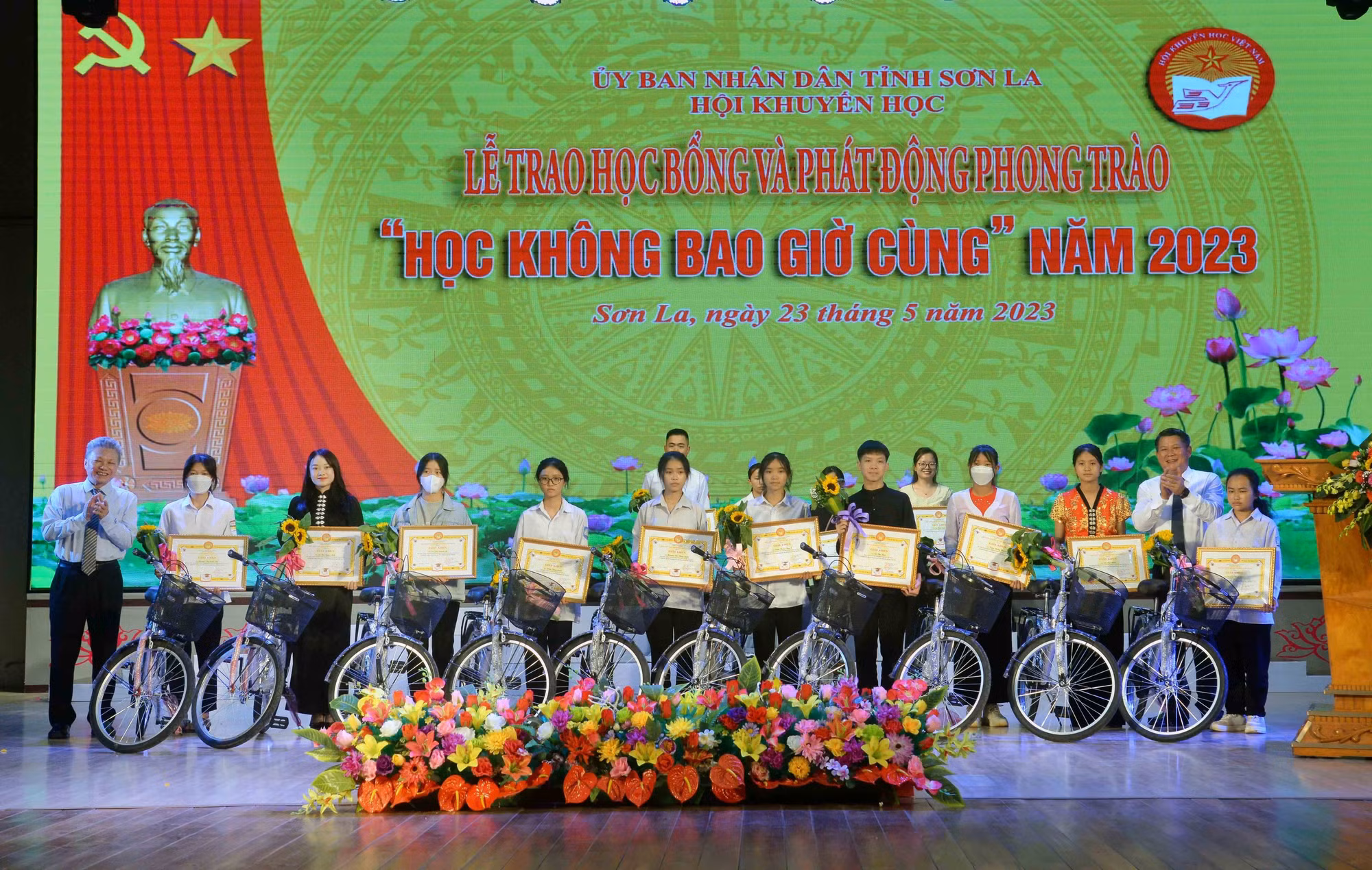 Ban Tổ chức trao Giấy khen của Hội Khuyến học tỉnh Sơn La và xe đạp cho các em học sinh. Ảnh: Quang Quyết - TTXVN