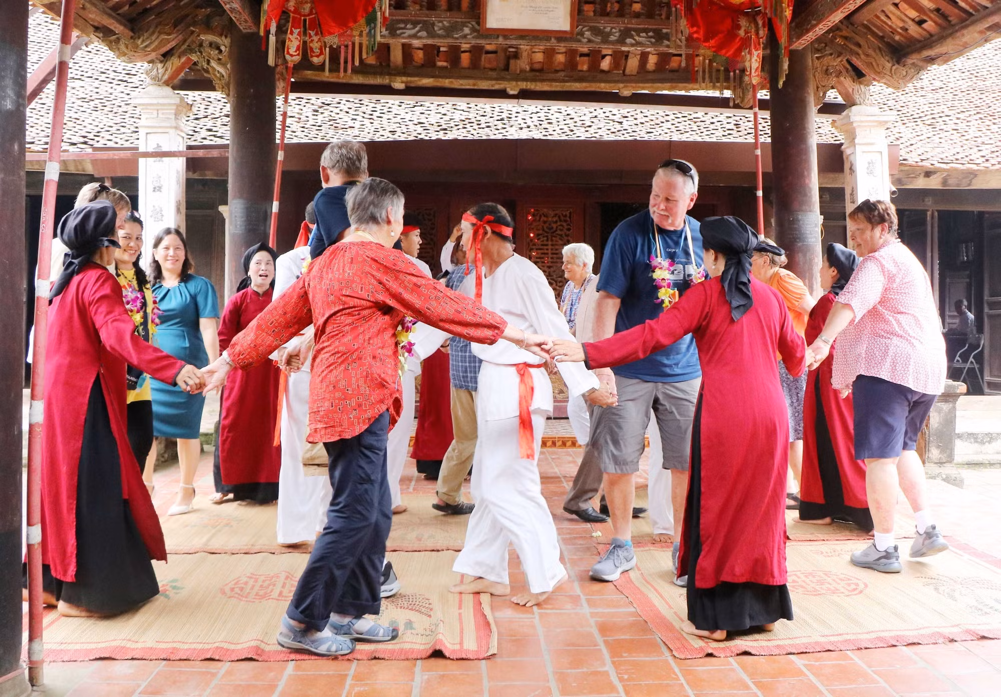 Du khách quốc tế cùng các nghệ nhân và người dân tham gia Hát Xoan tại đình cổ Hùng Lô (xã Hùng Lô, thành phố Việt Trì, tỉnh Phú Thọ). Ảnh: Trung Kiên - TTXVN