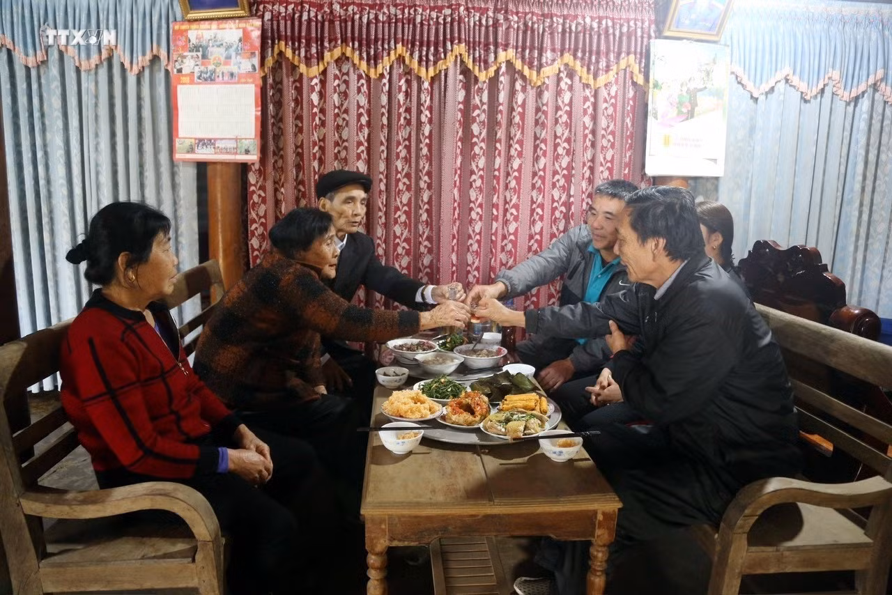 Một gia đình người Nguồn quây quần bên mâm cơm báo hiếu cha mẹ. Ảnh: TTXVN phát