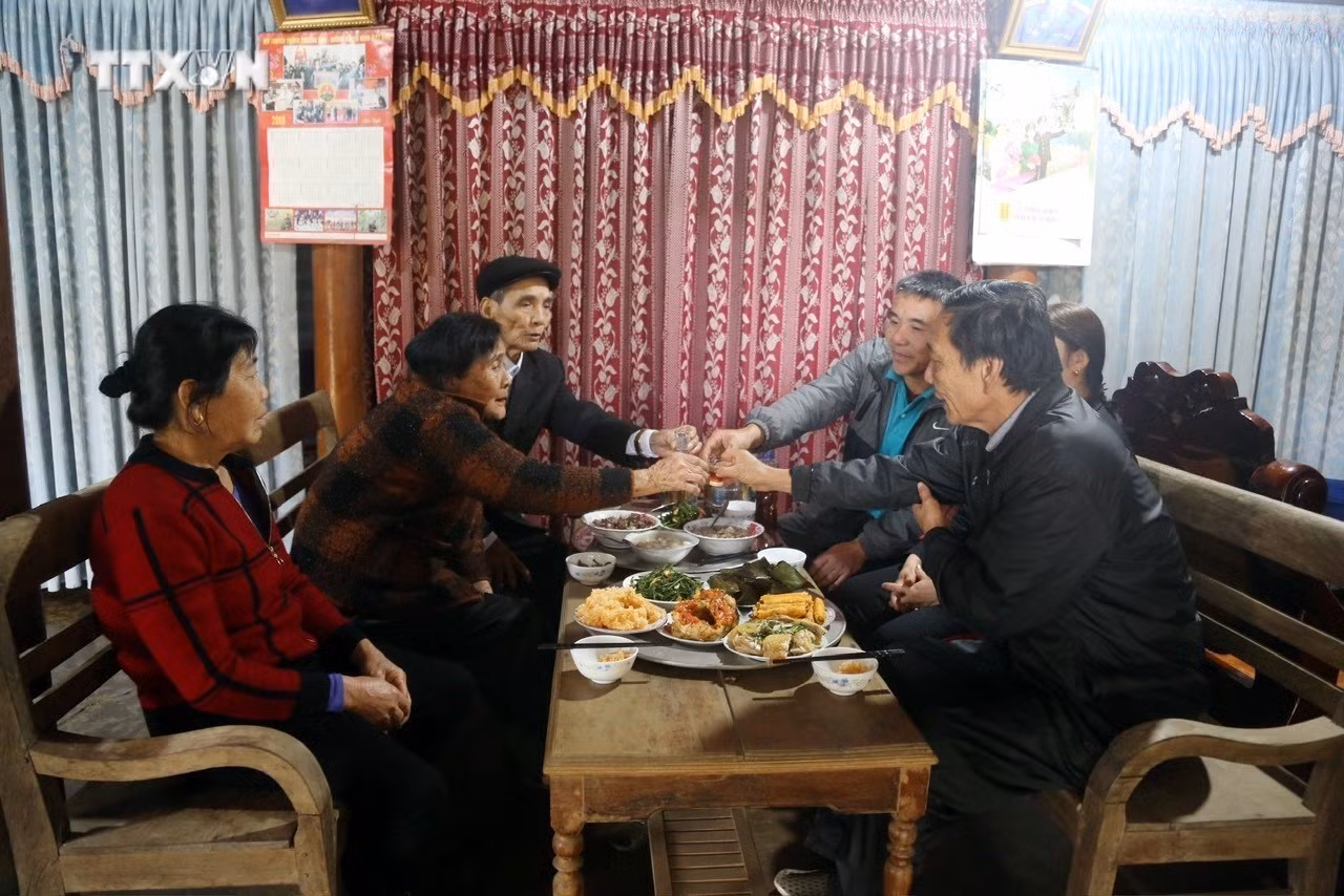 Một gia đình người Nguồn quây quần bên mâm cơm báo hiếu cha mẹ. Ảnh: TTXVN phát