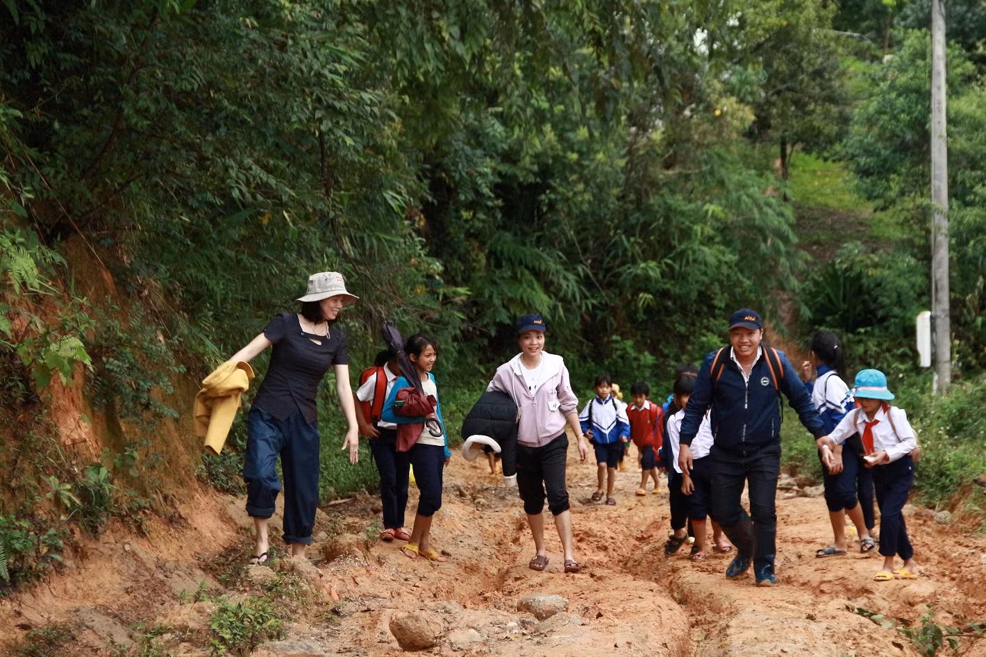 Cô Hồ Thị Thùy Vân (ngoài cùng bên trái) cùng đồng nghiệp vận động đưa học sinh đến lớp. Ảnh: baotintuc.vn