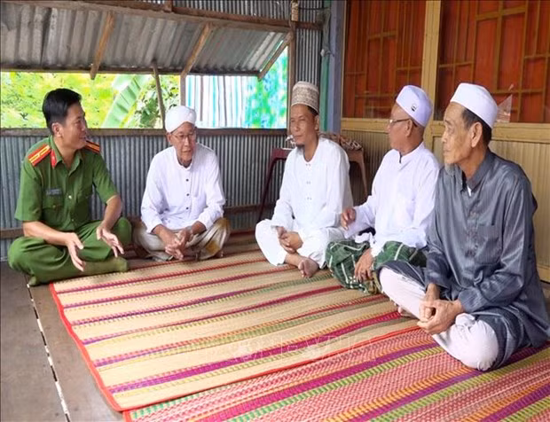 Công an xã Quốc Thái (An Phú, An Giang) gặp gỡ, trao đổi với các chức sắc trong đồng bào Chăm về tình hình an ninh trật tự tại địa phương. Ảnh: Thanh Sang - TTXVN