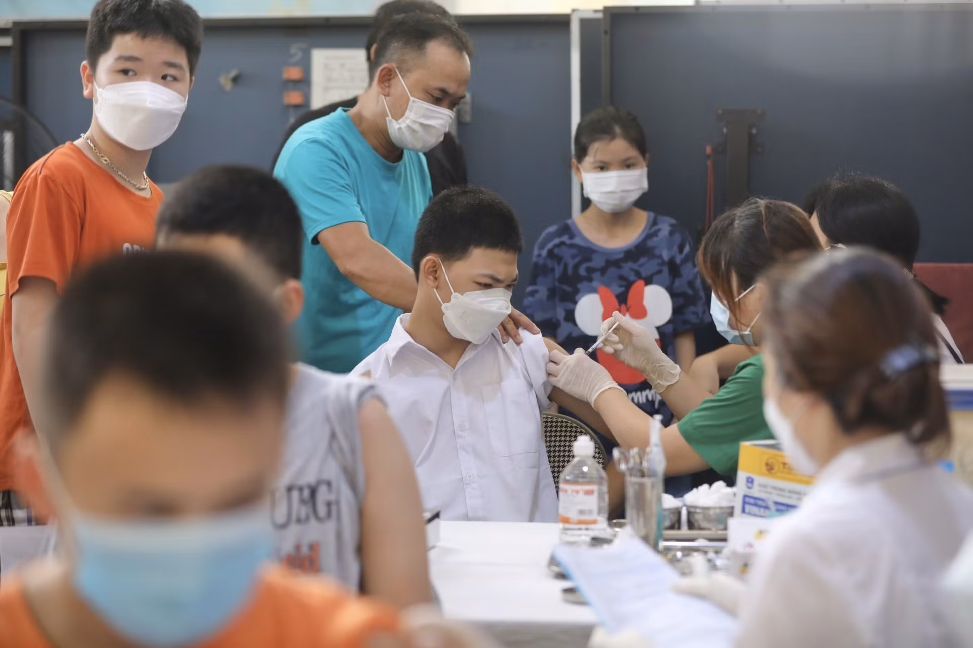 Nhân viên y tế quận Đống Đa tiêm vaccine cho học sinh tại điểm tiêm trường THCS Bế Văn Đàn (Hà Nội). Ảnh: Minh Quyết - TTXVN