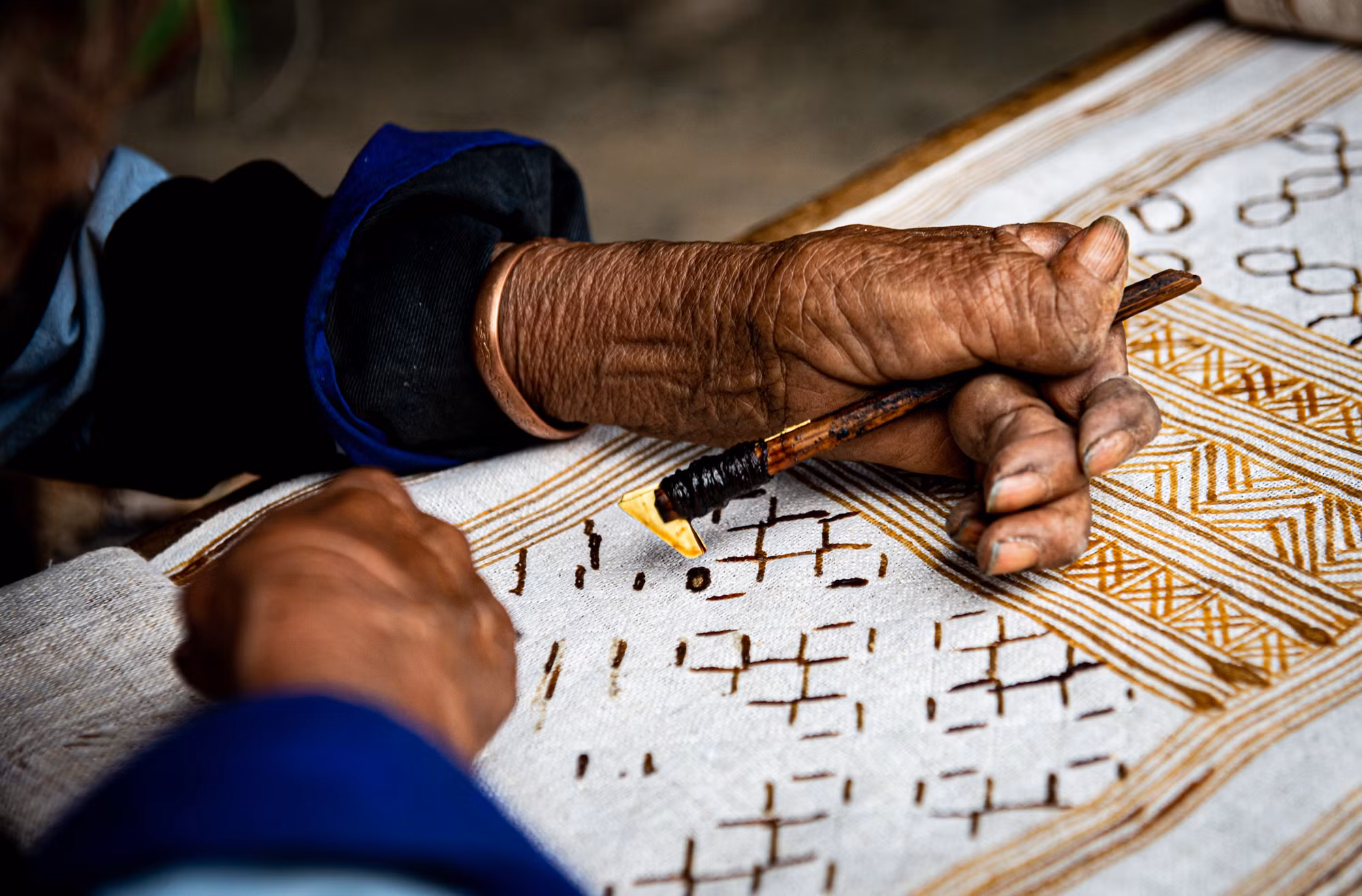Nghệ nhân vẽ sáp ong lên vải lanh. Ảnh:Nam Thái