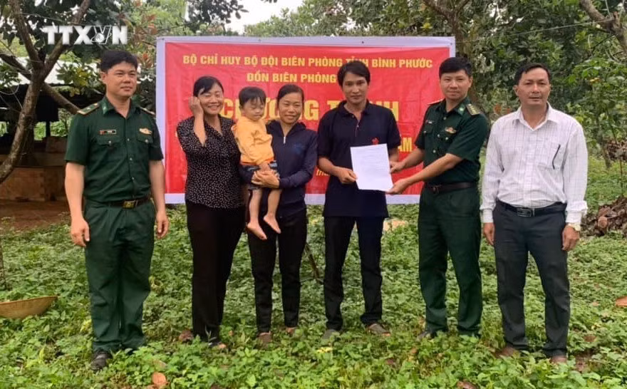 Đại diện Đồn Biên phòng Đắc Ơ (huyện biên giới Bù Gia Mập, Bình Phước) trao dê giống cho hai hộ nghèo xã Đắc Ơ. Ảnh: TTXVN phát