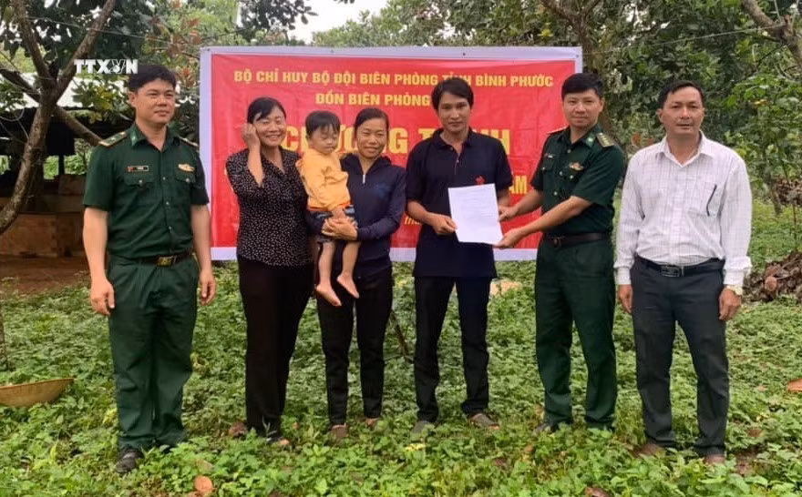 Đại diện Đồn Biên phòng Đắc Ơ (huyện biên giới Bù Gia Mập, Bình Phước) trao dê giống cho hai hộ nghèo xã Đắc Ơ. Ảnh: TTXVN phát