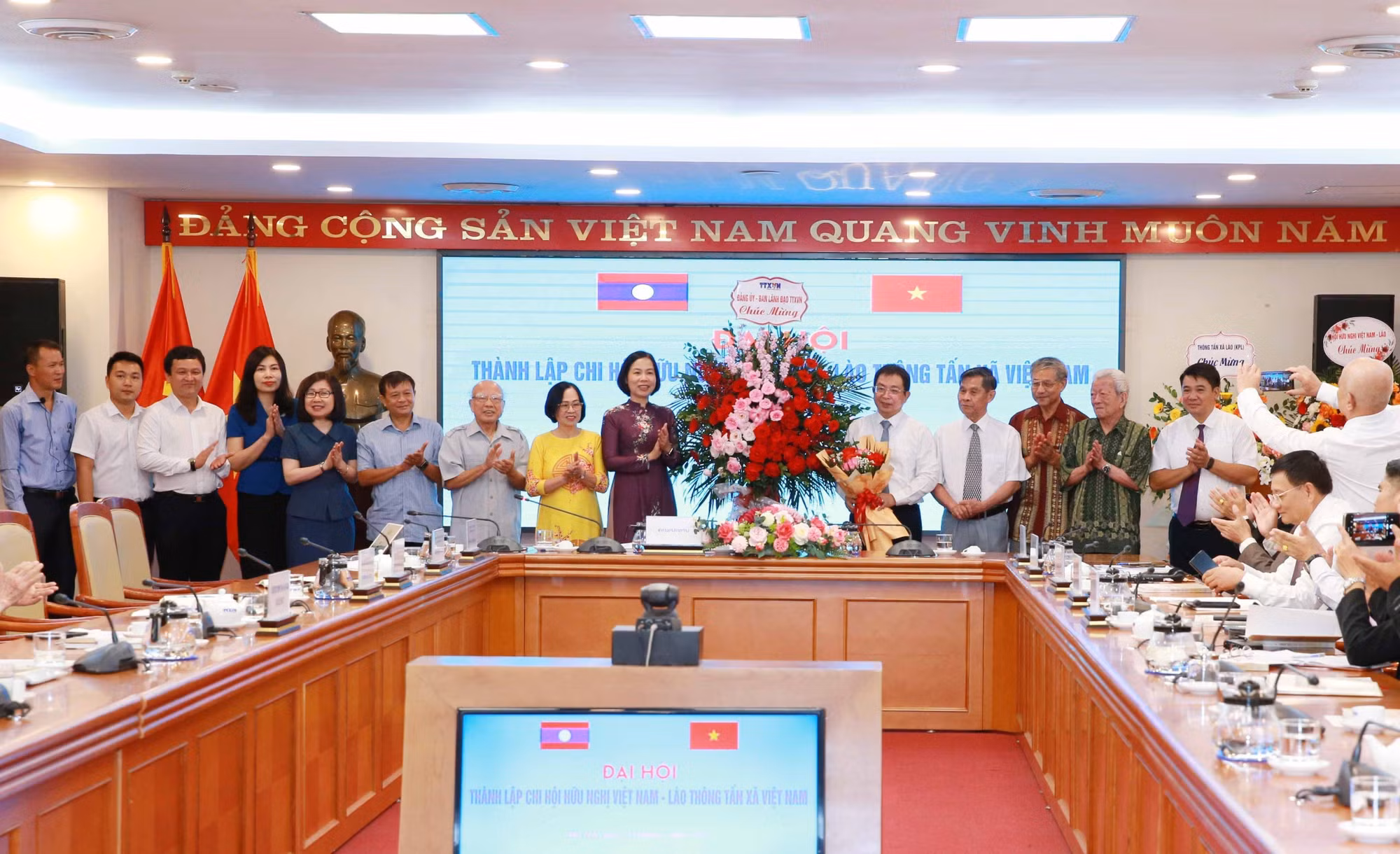 Đồng chí Vũ Việt Trang, Tổng giám đốc Thông tấn xã Việt Nam tặng hoa chúc mừng Ban Chấp hành Chi hội Hữu nghị Việt Nam - Lào Thông tấn xã Việt Nam. Ảnh: Phương Hoa - TTXVN