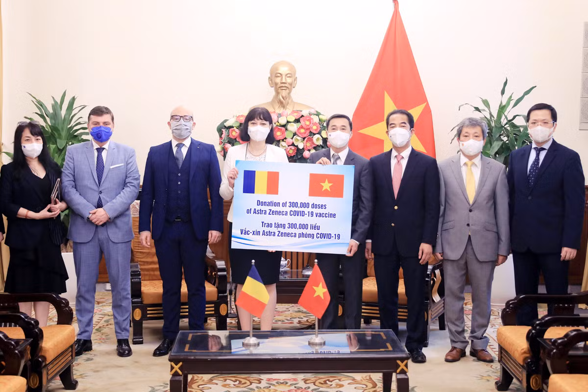 Thứ trưởng Bộ Ngoại giao Tô Anh Dũng và Thứ trưởng Bộ Y tế Trần Văn Thuấn đón nhận tượng trưng 300.000 liều vaccine COVID-19 từ Đại sứ Romania tại Việt Nam Cristina Romila.
