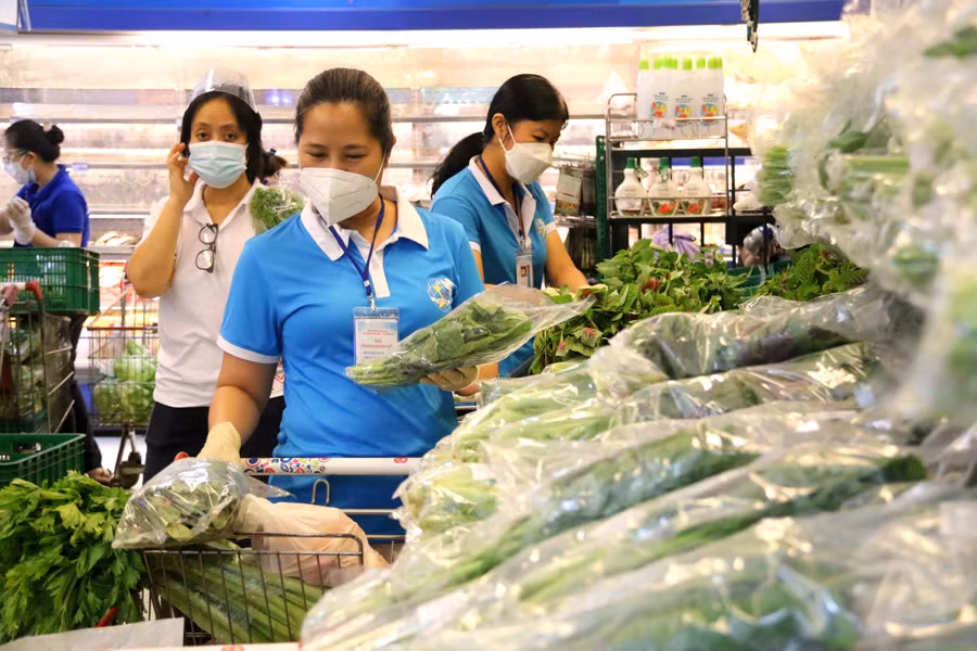 Hội viên Hội Liên hiệp phụ nữ Quận 3 đi chợ giúp dân mua hàng hóa, thực phẩm.