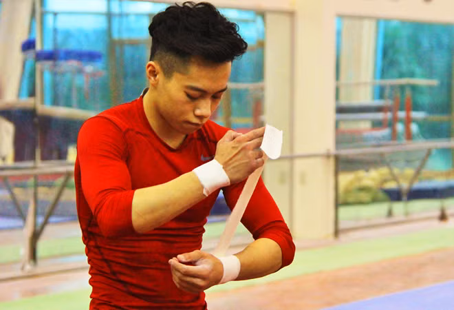 Sau mỗi động tác tập luyện, Tùng lại quấn lại băng bảo vệ đôi tay.