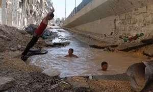 Trẻ em Syria phải tắm trong hố bom