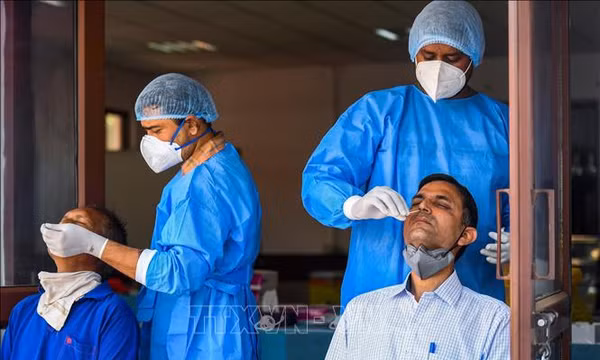 Nhân viên y tế lấy mẫu xét nghiệm COVID-19 cho người dân tại New Delhi, Ấn Độ. Ảnh: AFP/TTXVN (Không được sử dụng, chia sẻ bởi bên thứ ba)