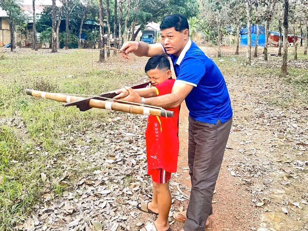 Anh Bùi Văn Miệt hướng dẫn con môn thể thao truyền thống.