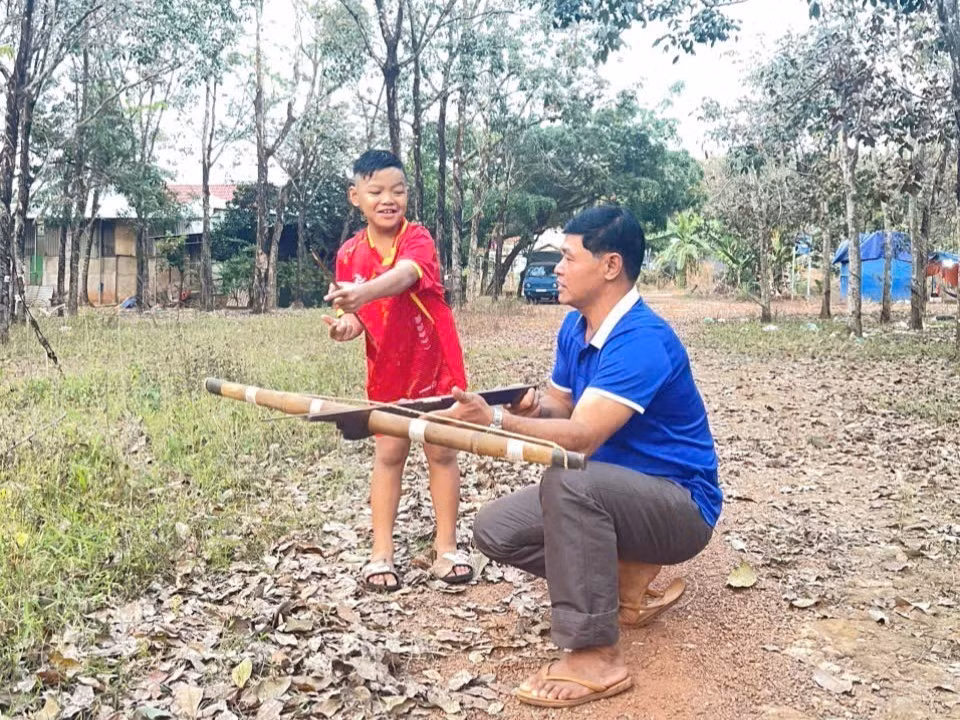 Anh Bùi Văn Miệt hướng dẫn con môn thể thao truyền thống.
