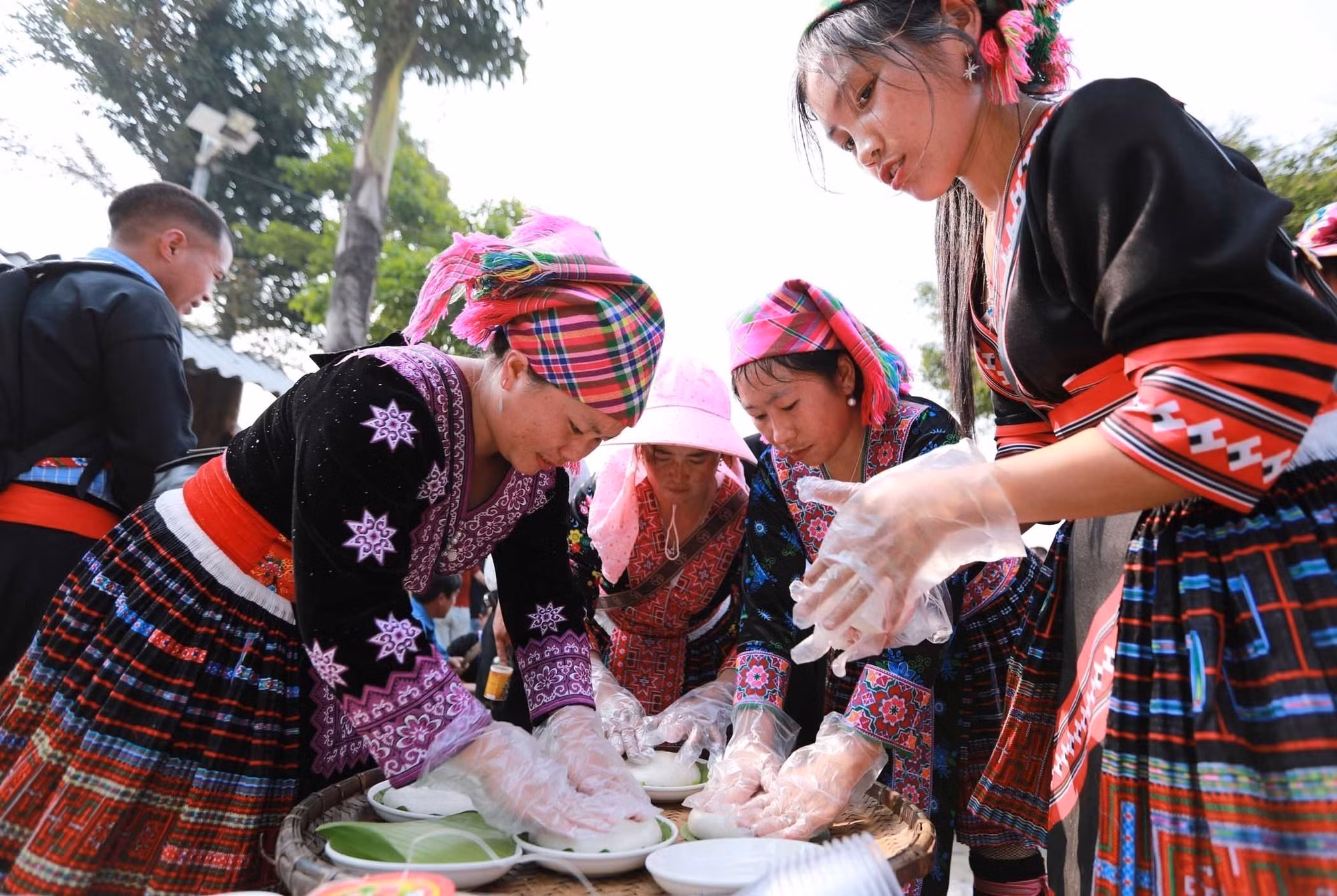 Mỗi người một việc, các thành viên nữ trong đội cắt sẵn lá để đựng bánh giầy sau khi giã xong.