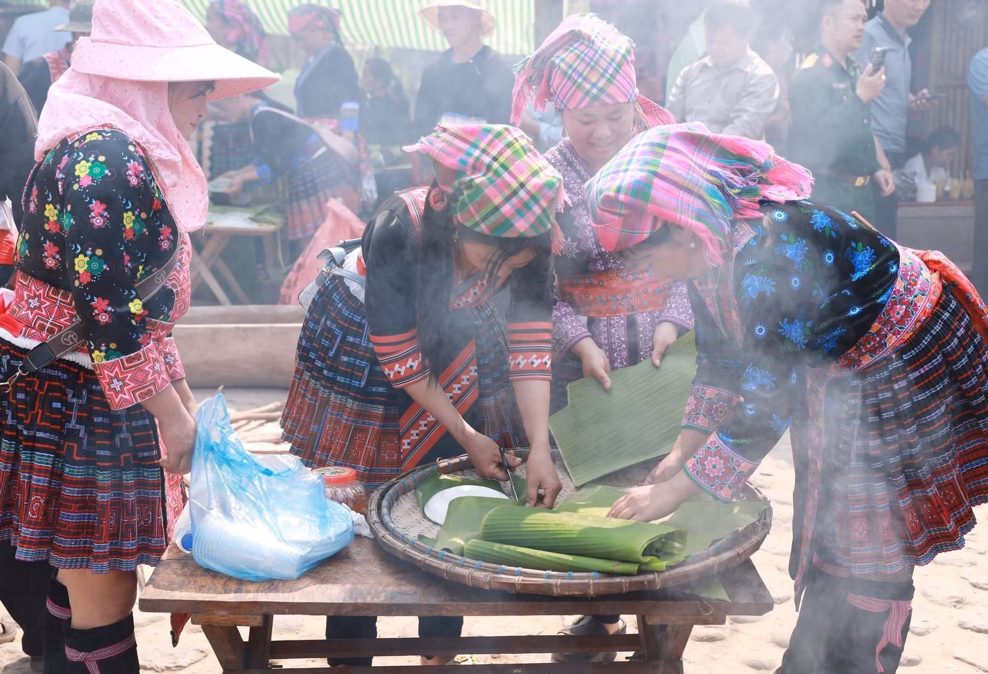Mỗi người một việc, các thành viên nữ trong đội cắt sẵn lá để đựng bánh giầy sau khi giã xong.