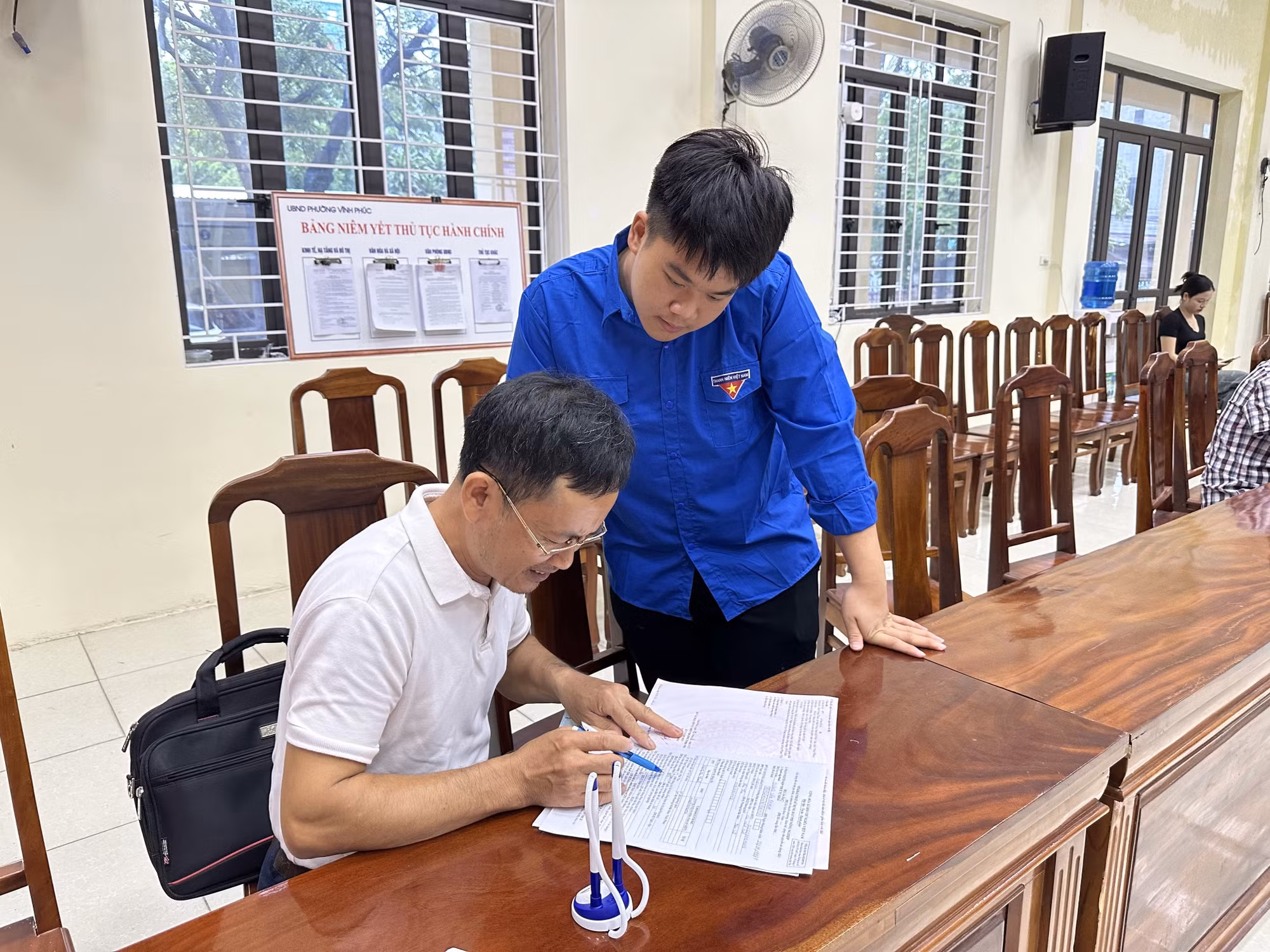 Đoàn viên thanh niên phường Vĩnh Phúc hướng dẫn người dân làm các thủ tục hành chính.