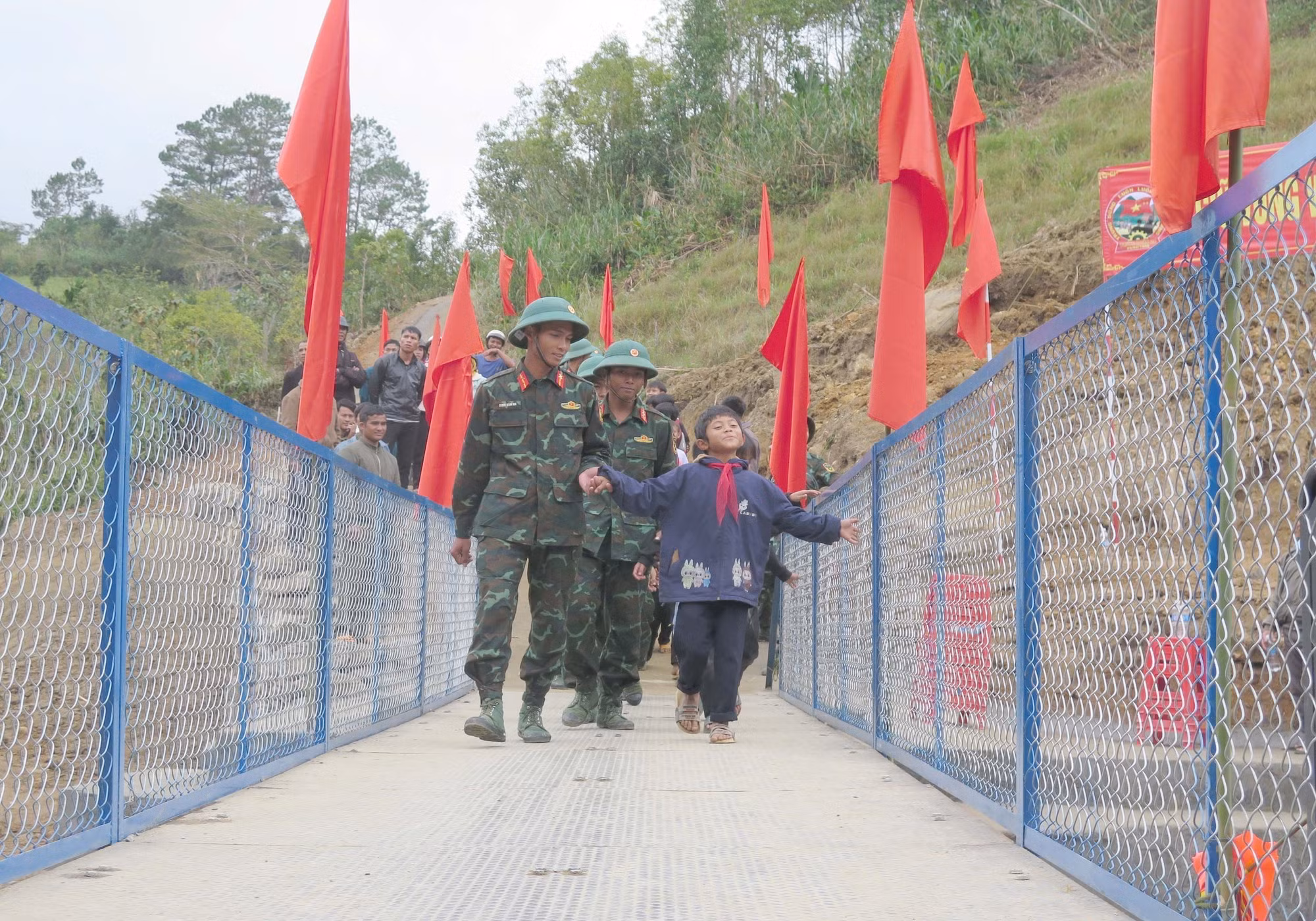 Các cán bộ, chiến sĩ đưa học sinh qua cầu.
