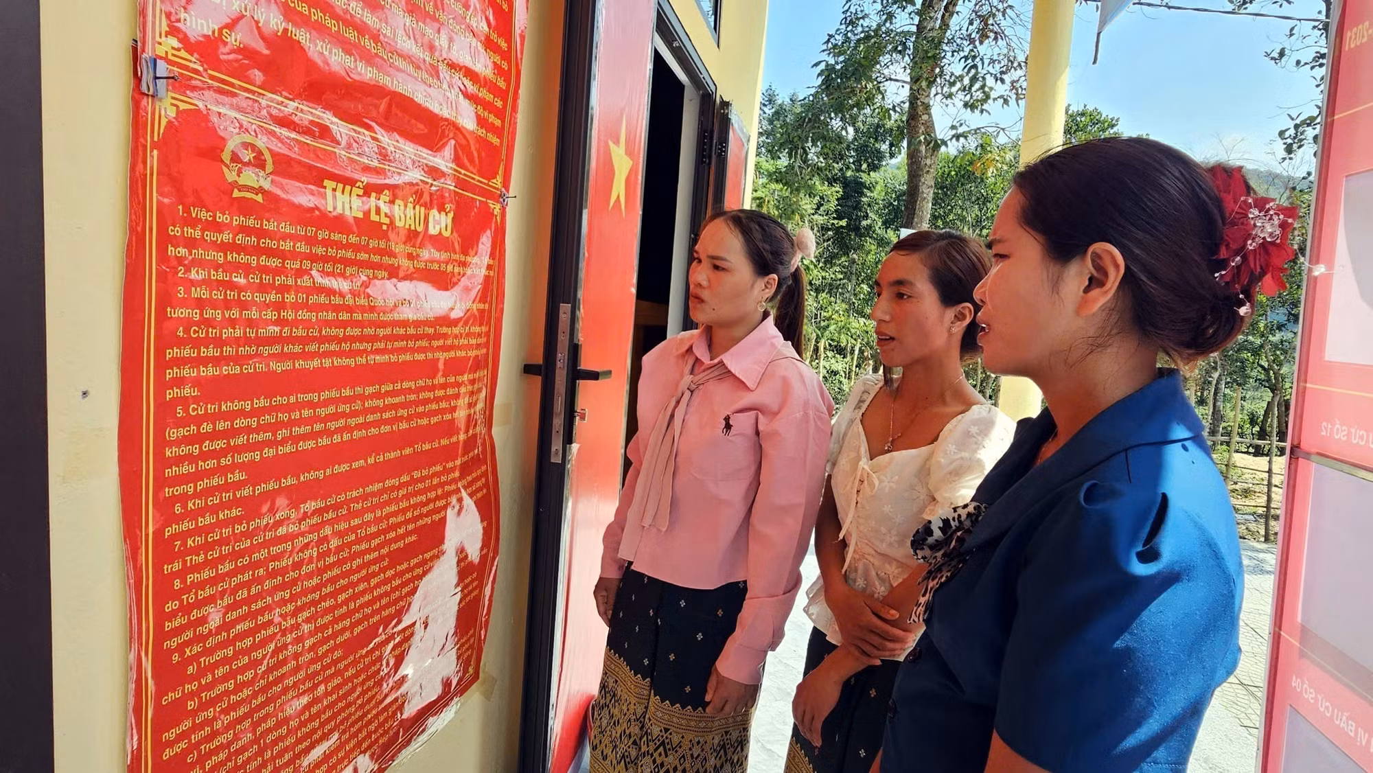 Đồng bào Bru - Vân Kiều (xã Trường Sơn, Quảng Trị) đọc các quy định về công tác bầu cử. Ảnh: TTXVN phát