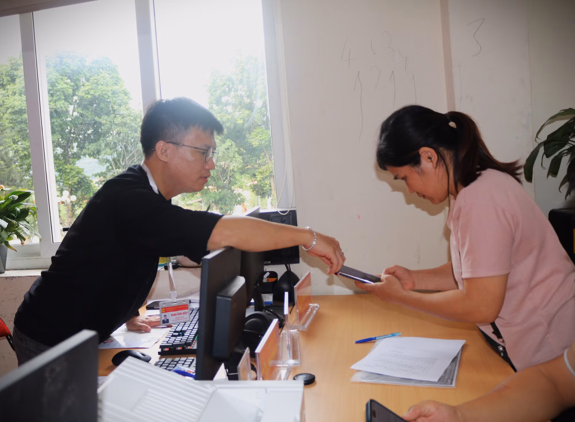 Cán bộ Trung tâm phục vụ hành chính công xã Phục Hòa hướng dẫn người dân làm thủ tục trên thiết bị thông minh.