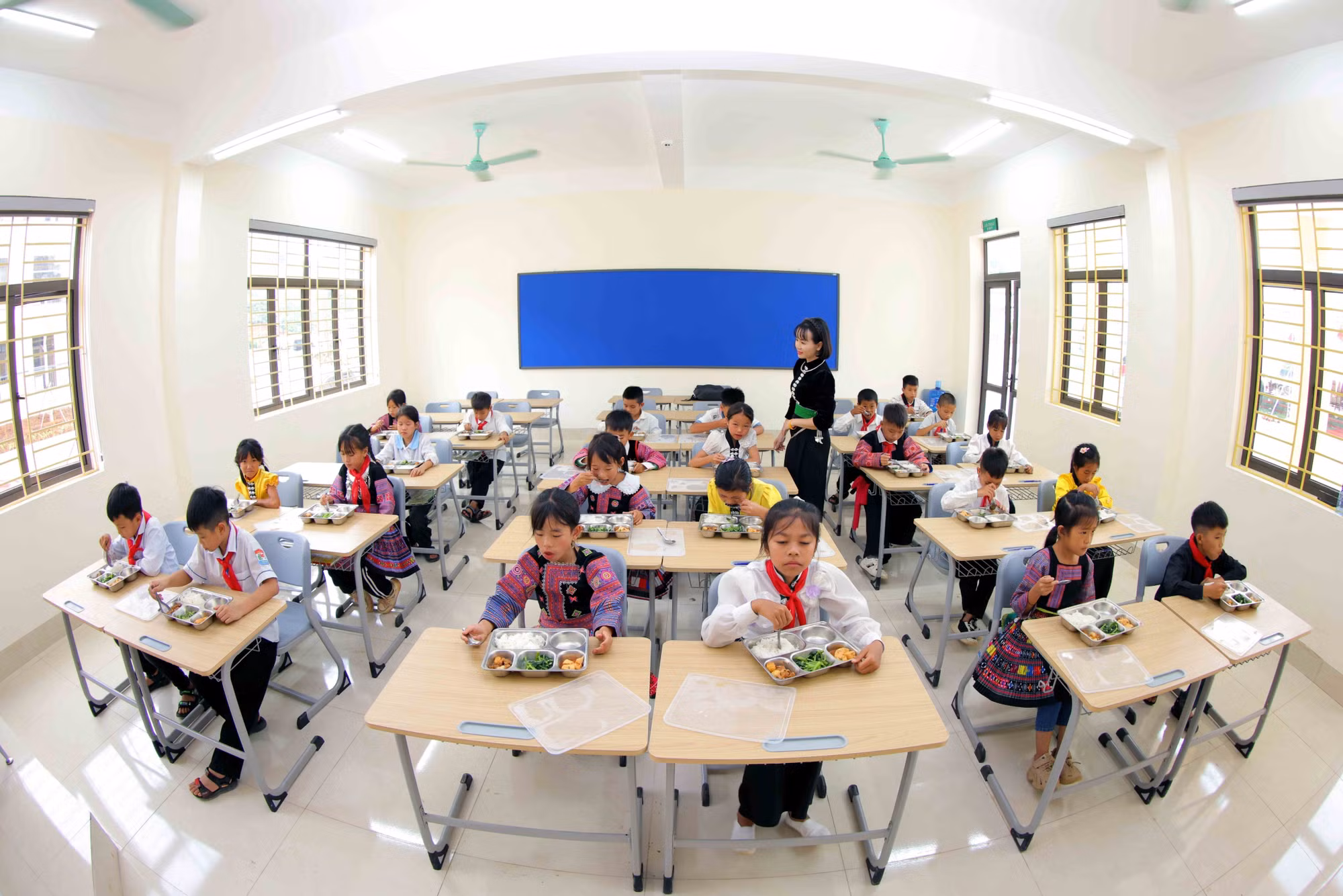 Giờ ăn trưa tại lớp học của Trường phổ thông nội trú Tiểu học và Trung học cơ sở Yên Sơn mới được khánh thành. Ảnh: Quang Quyết/TTXVN