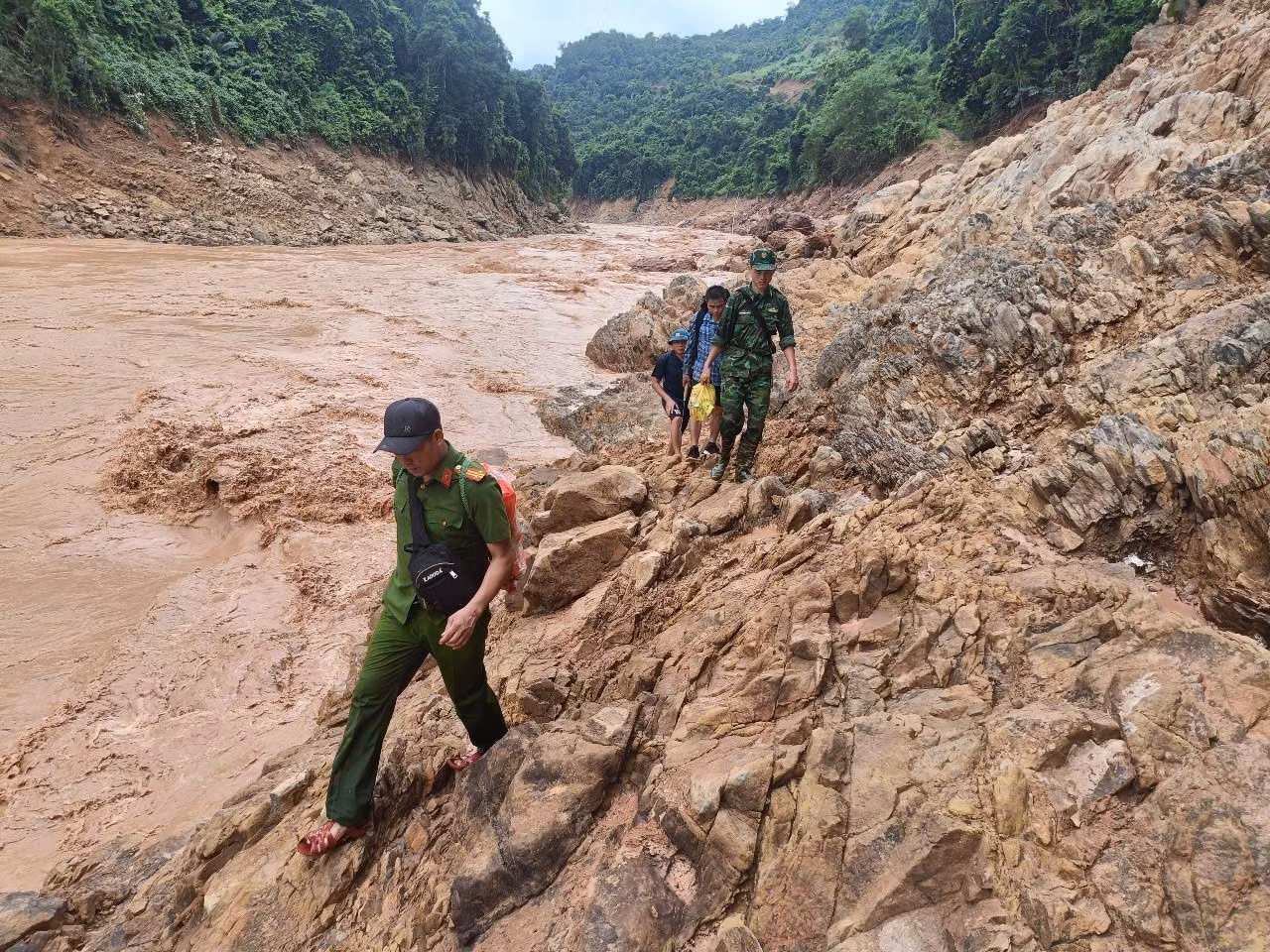 Tổ công tác vất vả di chuyển theo vách đá ngược thượng nguồn sông Nậm Mộ trên hành trình tiếp cận bản Cha Nga (xã Mỹ Lý, tỉnh Nghệ An). Ảnh: TTXVN phát