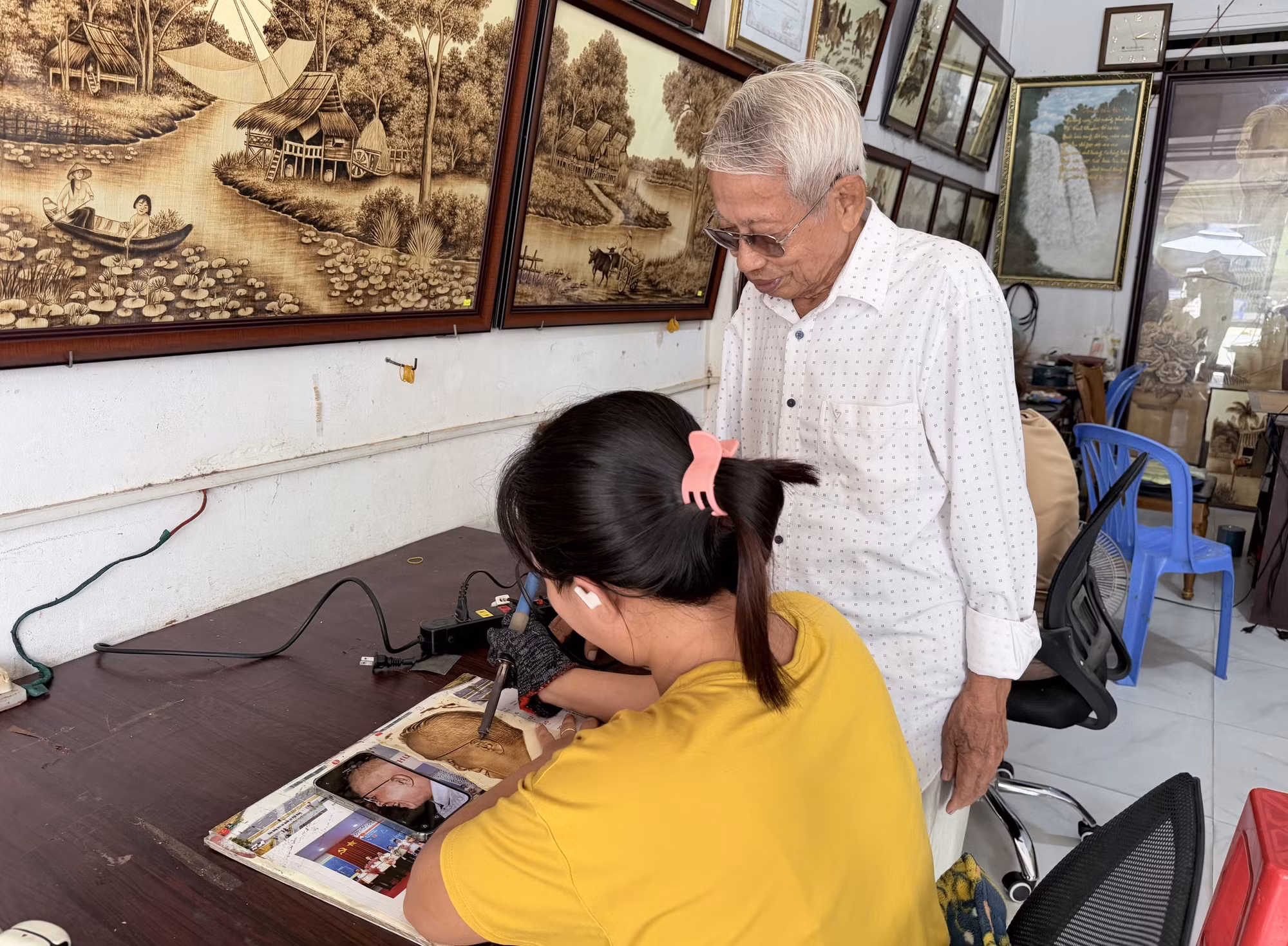 Nghệ nhân Võ Văn Tạng hướng dẫn học trò khắc hoạ chân dung Chủ tịch Tôn Đức Thắng trên nền lá thốt.