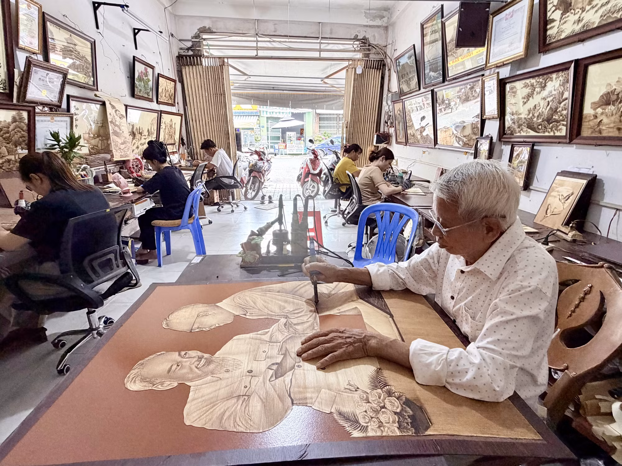 Nghệ nhân Võ Văn Tạng còn truyền dạy nghề cho các học trò sáng tạo tranh bút lửa trên lá thốt nốt.