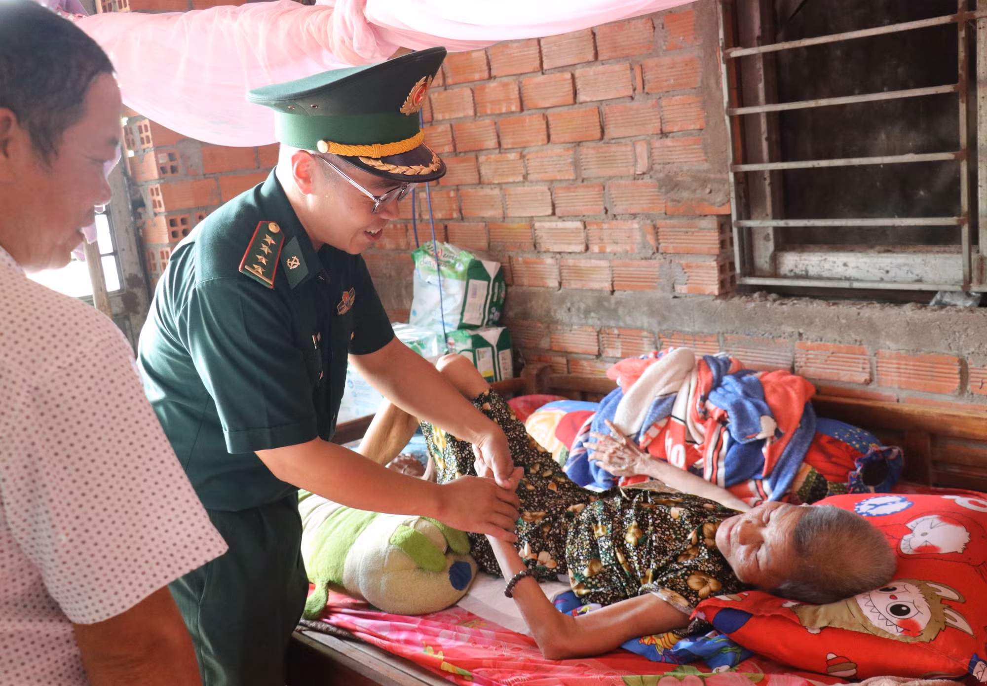 Đại úy Phạm Việt Tiến ân cần thăm hỏi, động viên người cao tuổi có hoàn cảnh khó khăn, thể hiện sự sẻ chia của người lính biên phòng với nhân dân nơi biên giới.