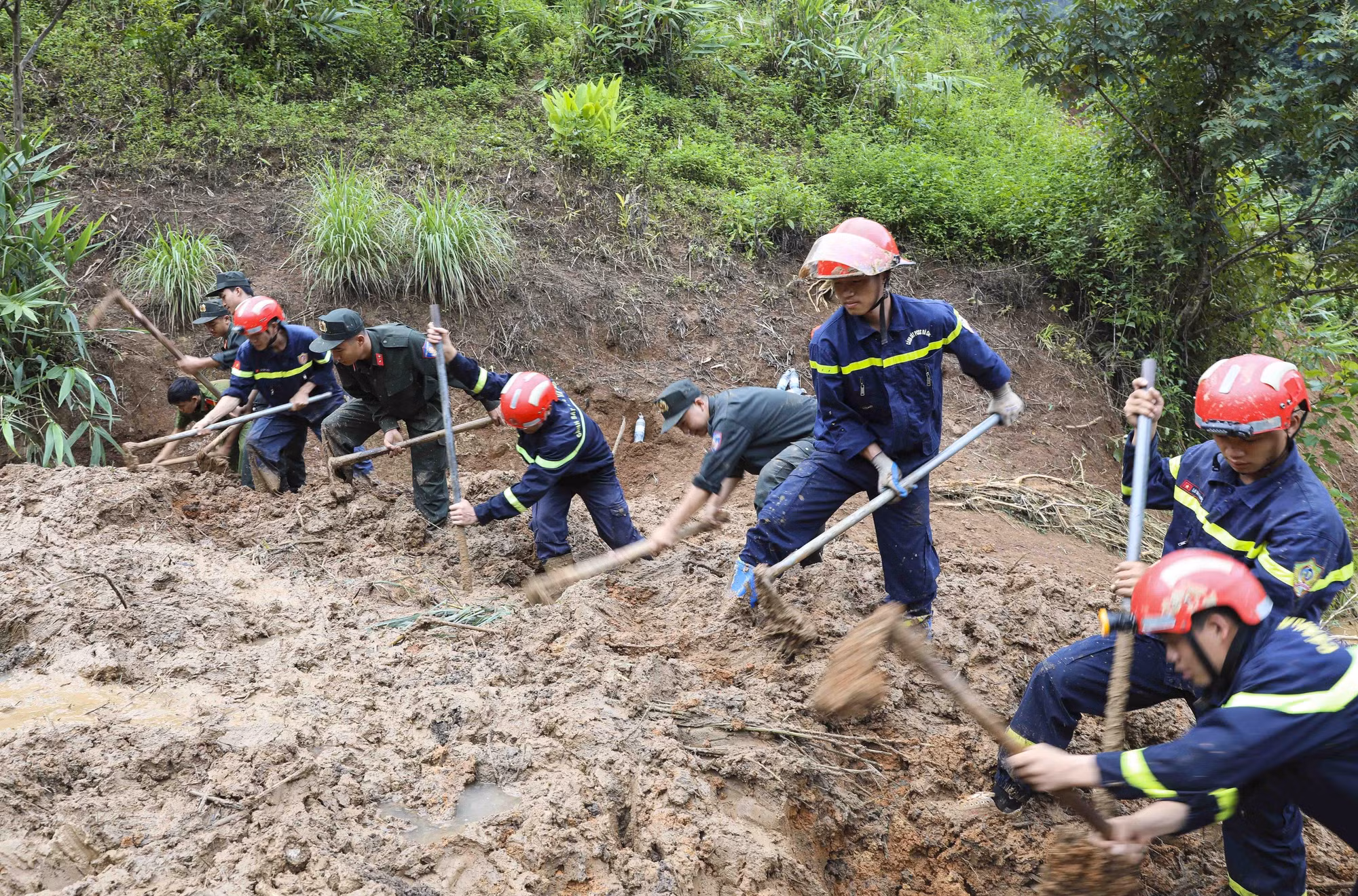 Các chiến sĩ lực lượng Cảnh sát PCCC và cứu nạn, cứu hộ tham gia tìm kiếm nạn nhân mất tích do lũ quét, sạt lở đất ở bản Háng Pu Xi, xã Xa Dung (ảnh chụp lúc 6h57 ngày 2/8). Ảnh: Xuân Tư/TTXVN