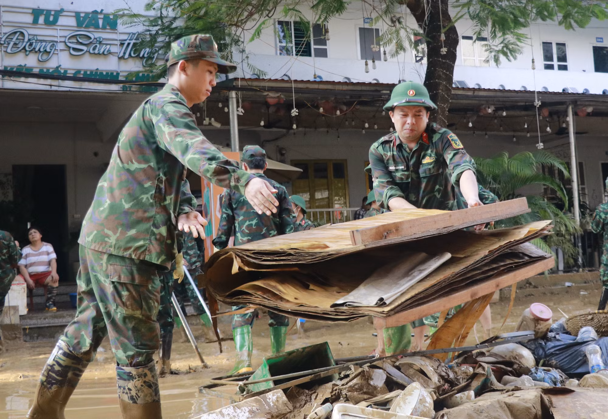 Lực lượng bộ đội hỗ trợ người dân phường Yên Bái dọn dẹp đồ dùng.