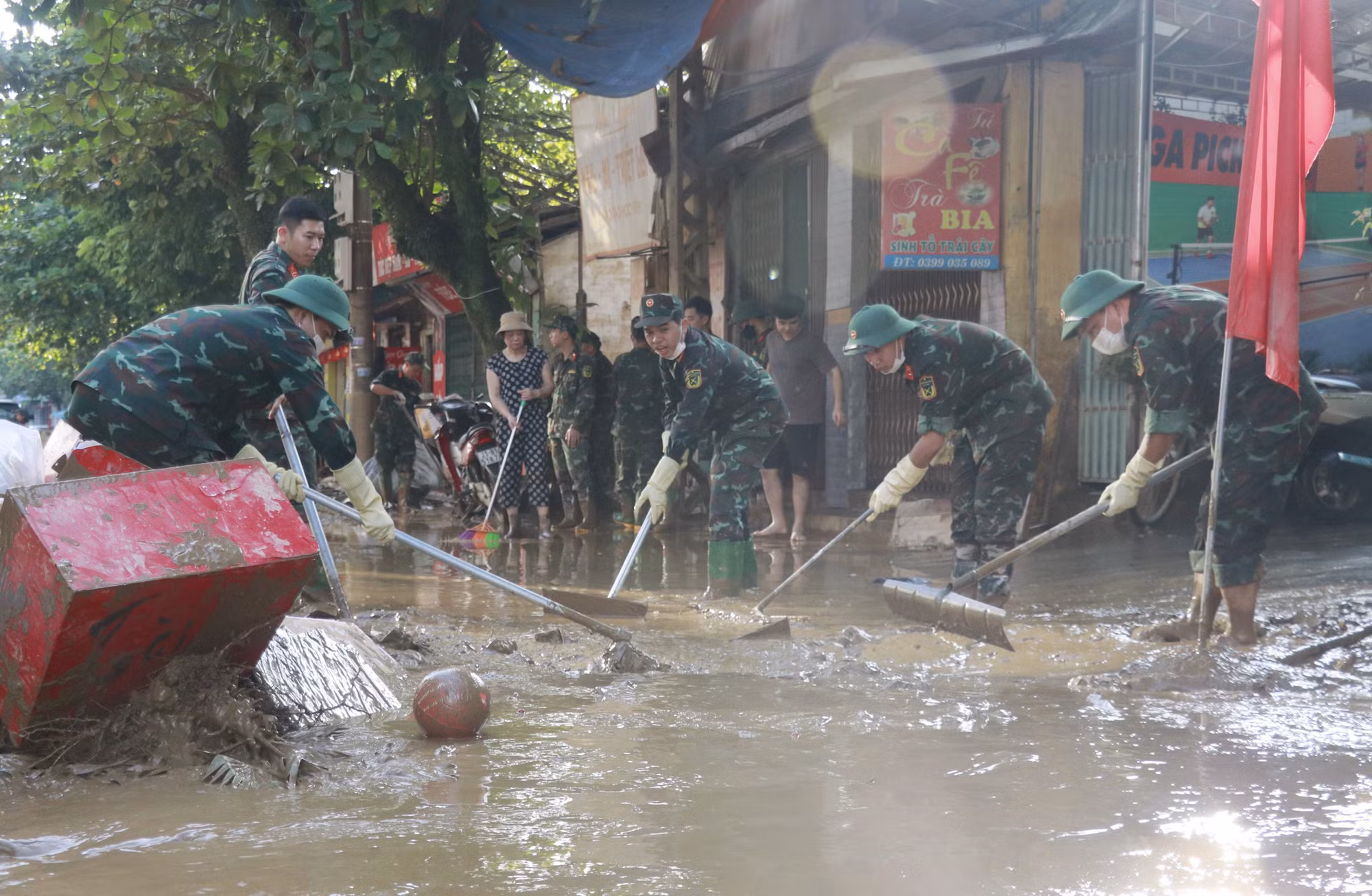Lực lượng bộ đội hỗ trợ người dân phường Yên Bái dọn dẹp bùn đất trên đường.